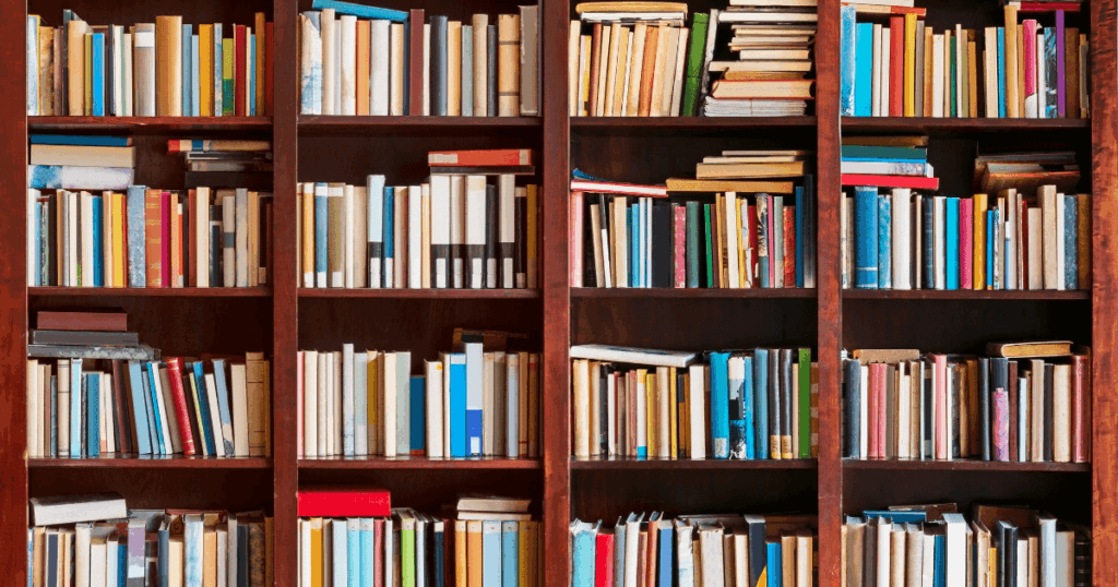 En stor bogreol i træ fyldt med bøger i forskellige størrelser og farver, arrangeret både lodret og vandret på flere hylder - perfekt inspiration til at forbedre din skrivning.